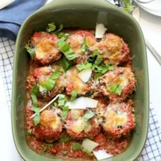 a green casserole dish filled with meatballs and cheese