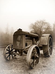 an old tractor sitting in the middle of a field