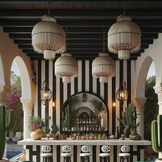 the bar is decorated with black and white striped wallpaper, cactus plants, and hanging chandeliers