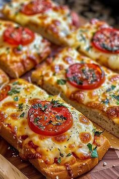 several slices of pizza with tomatoes and cheese on them sitting on a wooden platter