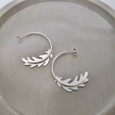 Sterling Silver Oak Leaf Hoop Earrings  These earrings are very comfortable to wear every day, or they can be teamed with the matching necklace for special occasions These earrings come beautifully gift packaged in one of my branded box tied with luxury ribbon. Handmade from eco friendly sterling silver in my woorkshop in Northamptonshire All of my jewellery is meant to be worn for many years so to look after your special piece I recommend that you store it carefully in its box when its not bein Oak Leaf Jewelry, Seaglass Jewellery, Ribbon Handmade, Silver Oak, Statement Hoop Earrings, Metalsmithing Jewelry, Jewellery Inspiration, Jewellery Uk