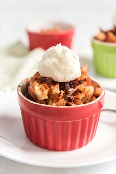 a red bowl filled with food on top of a white plate