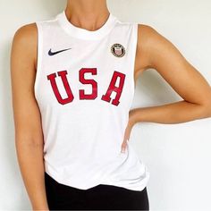 a woman wearing a usa tank top and black pants with her hands on her hips