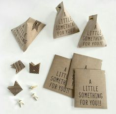 several pieces of brown paper with words on them and some small pins attached to it