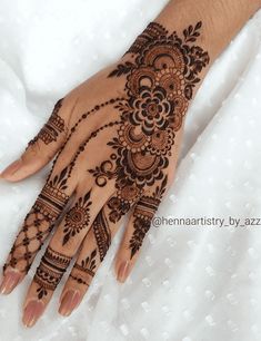 a woman's hand is decorated with hennap and intricate designs on it