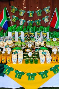 a table topped with lots of green and white desserts on top of a yellow table cloth