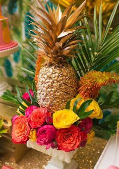 a pineapple surrounded by flowers and greenery