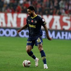 a man kicking a soccer ball on top of a field