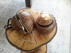 two wooden bowls sitting on top of a piece of wood with chains hanging from it