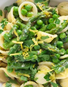 a white bowl filled with pasta and peas