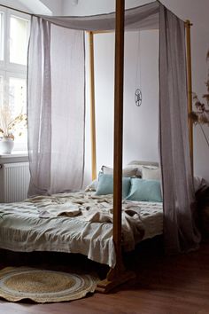 a canopy bed in a bedroom with white walls