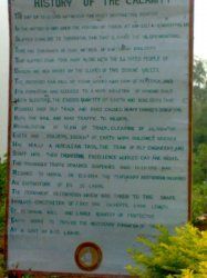 a sign in front of some trees and bushes that says history of the calamit