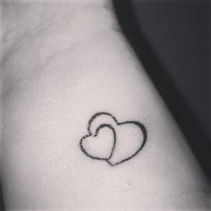 two hearts tattoo on the left side of the right arm, with one heart in the middle