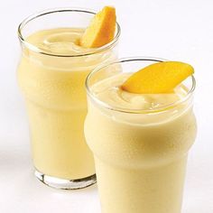 two glasses filled with orange juice and garnished with an orange slice