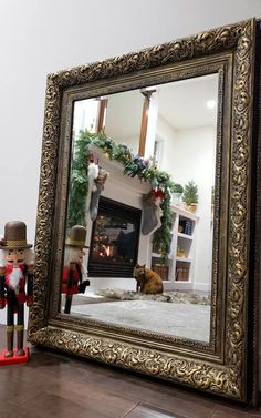 a fire place with a mirror on the floor and a toy soldier standing in front of it