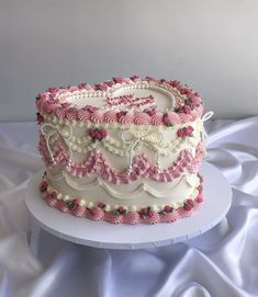 a white and pink cake sitting on top of a table