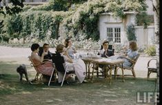 a group of people sitting around a table outside