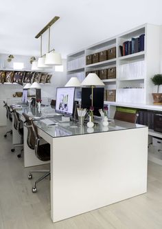 an office with two desks and several computer screens