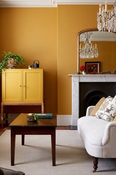 a living room filled with furniture and a fire place next to a yellow cabinet in front of a fireplace