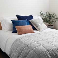 a white bed topped with lots of pillows