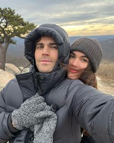 a man and woman taking a selfie in the mountains