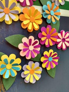 colorful paper flowers sitting on top of a table