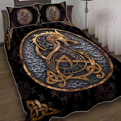 a bed covered in a black and gold cover with an intricate dragon design on it