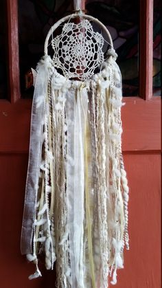 a white dream catcher hanging on the side of a door