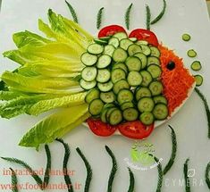 a plate with cucumbers, carrots and lettuce arranged on it