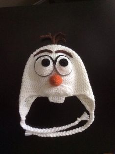 a crocheted hat with eyes and nose