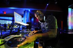 a man in headphones standing next to a dj's turntable