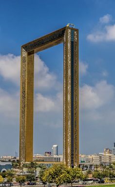 a tall clock tower sitting in the middle of a park next to a lush green field