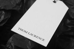 black and white photograph of a tag with the word'thomas laurence'on it