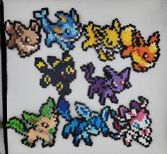 a bunch of pixel art pieces on a white surface with black trimmings in the shape of pokemon's heads