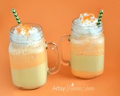 two mugs filled with liquid and topped with whipped cream, orange zest and sprinkles