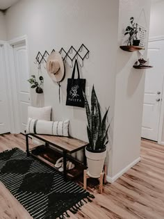 a living room filled with furniture and plants on top of a hard wood flooring