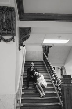 a man and woman sitting on top of stairs