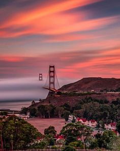 the golden gate bridge in san francisco, california at sunset with clouds moving over it