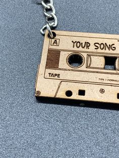 a wooden necklace with an old fashioned tape recorder on it that says, you're song time