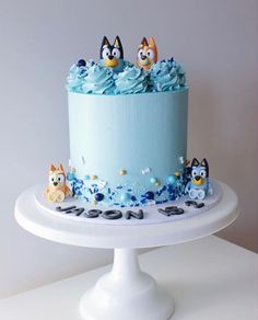 a blue frosted cake decorated with cartoon characters