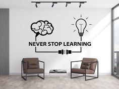 a living room with two chairs and a wall sticker that says never stop learning