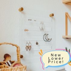 there is a wall mounted jewelry rack with earrings on it and a sign that says new lower price