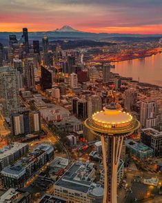 an aerial view of the space needle in seattle at sunset with mt rainier in the background