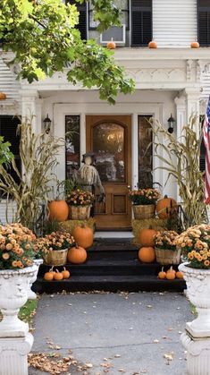 a house with pumpkins and gourds on the front porch