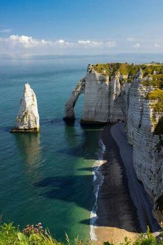 the beach is surrounded by cliffs and water