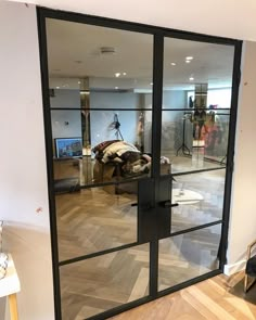 an open glass door with people walking in the room behind it and on the other side