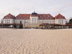 a large white building sitting on top of a sandy beach