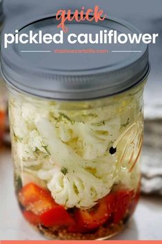 a mason jar filled with pickled cauliflower and tomatoes