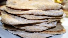 a stack of pita bread sitting on top of a white plate