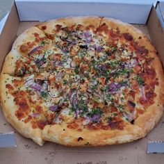 a large pizza in a box with toppings on the top is ready to be eaten